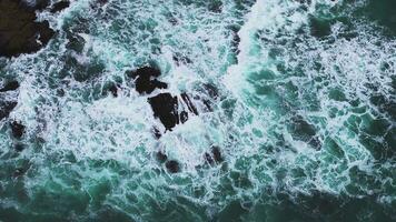 Aerial view of the Pacific Ocean waves hitting the cliff rocks. Top view of the waves. Sea shore during the storm. video