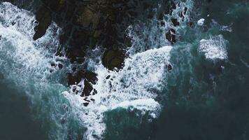 Aerial view of the Pacific Ocean waves hitting the cliff rocks. Top view of the waves. Sea shore during the storm. video