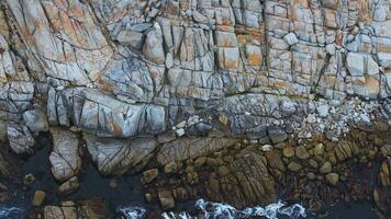 Aerial view of the Pacific Ocean waves hitting the cliff rocks. Top view of the waves. Sea shore during the storm. video