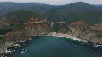 The Pacific Ocean washes onto the beautiful seashore of California, not far south of Monterey. The Pacific Coast Highway runs over the Bixby Bridge and right along this incredibly scenic coast. video