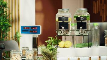 Close up of electronic scale in eco friendly zero waste supermarket next to freshly harvested produce. Panning shot of weighing machine in green living local shop used for bulk products video