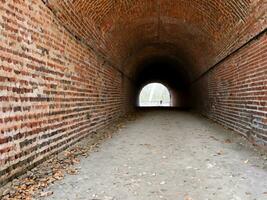 the red brick wall with a large stone tunnel photo