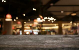 Mock up for space. Empty dark wooden table in front of abstract blurred bokeh background of restaurant . can be used for display or montage your product photo