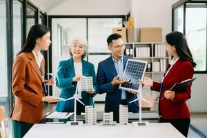 Group of alternative energy engineers discussing a project with a worker businesspeople a meeting in solar cell panel and Solar Energy Environment city Concept. photo