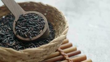 Black Rice Grains in a wooden bowl . video