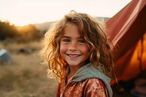 retrato de linda pequeño niña a cámara mientras en pie cerca cámping tienda a puesta de sol ai generado foto