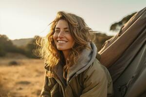 Portrait of girl looking at camera while near camping tent at sunset AI generated photo