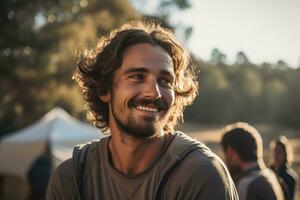 retrato de hombre mirando a cámara mientras cerca cámping tienda a puesta de sol ai generado foto