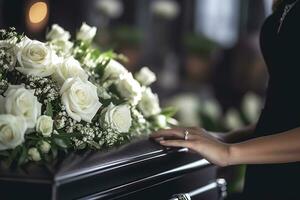 Closeup of a woman's hand placing a bouquet of white roses in a coffin.Funeral Concept AI generated photo