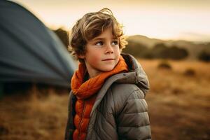 Portrait of a cute boy looking at camera while near his tent in nature AI generated photo