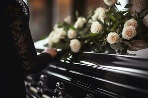 Closeup of a woman's hand placing a bouquet of white roses in a coffin.Funeral Concept AI generated photo