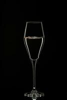 Backlit wine champagne glass with golden liquid photo