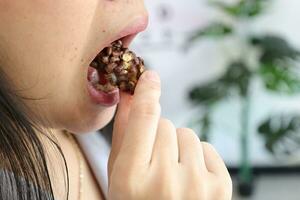 Close-up of a woman's mouth eating food photo