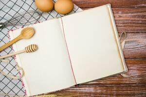 Blank vintage recipe book and on the wooden kitchen table. Close-up. Place for text. Top view. photo