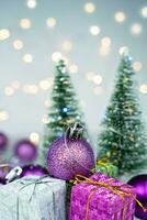 Festive New Year or Christmas composition with a gift boxes and Christmas trees with bokeh in the background. New Year card. Close-up. Selective focus. photo