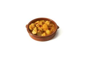 Potato stew with cod, served in a clay bowl. Isolated on white background. Spanish food concept. photo