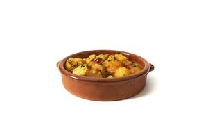 Potato stew with cod, served in a clay bowl. Isolated on white background. Spanish food concept. photo