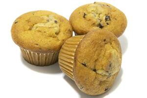 Muffins with chocolate flecks isolated on a white background. Muffins are made mainly from wheat flour, egg, vegetable oil, cow's milk, baking powder, essence ,vanilla being the most common, and sugar photo