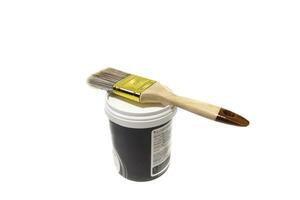 Paint brush on top of a paint pot, isolated on white background. Bristles can be made of various materials, such as natural hair, synthetic fibers, or a combination of both. photo