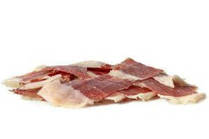 Sliced Iberian Serrano ham isolated on white background. Iberian serrano ham is a Spanish delicacy,famous for its smoky flavor and tender, salty texture, the richness of the Iberian culinary tradition photo