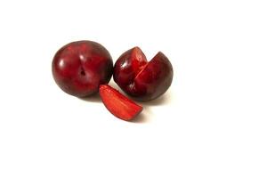 Red plum with red flesh, isolated on a white background. The red plum is juicy and sweet, perfect to enjoy as a snack or in delicious recipes. photo