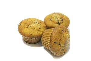 Muffins with chocolate flecks isolated on a white background. Muffins are made mainly from wheat flour, egg, vegetable oil, cow's milk, baking powder, essence ,vanilla being the most common, and sugar photo