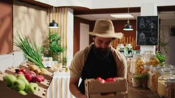 lojista A chegar dentro eco amigáveis supermercado com recentemente colhido orgânico Comida estoque. comerciante reabastecimento local Vizinhança mercearia fazer compras com produtos químicos livre legumes enquanto conversando com cliente video