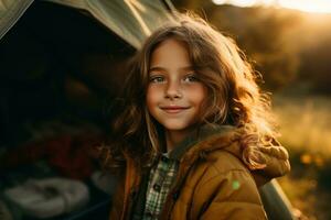 Portrait of cute little girl at camera while standing near camping tent at sunset AI generated photo