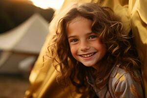 retrato de linda pequeño niña a cámara mientras en pie cerca cámping tienda a puesta de sol ai generado foto