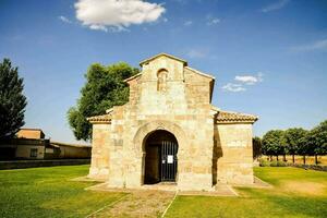 un Iglesia en el medio de un campo con un azul cielo foto