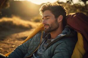 Portrait of man looking at camera while near camping tent at sunset AI generated photo