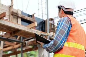 inspector or engineer is inspecting construction and quality assurance new house using a checklist. Engineers or architects or contactor work to build the house before handing it over to the homeowner photo