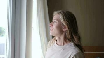 closeup of woman waking up and stretching in the morning in hotel room by the window video