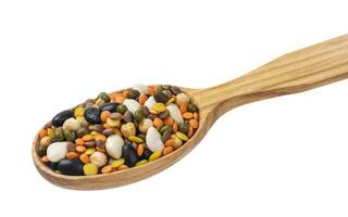 Legumes mix in wooden spoon isolated on white background. photo