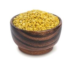 Yellow lentils in wooden bowl isolated on white background photo