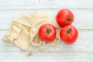 Reusable eco bags for shopping with tomato, replacing plastic bags photo