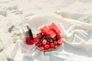 Champagne with a tray of fruits, strawberries and cherries on a picnic photo