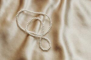 Pearl bijouterie beads on silk texture background. photo