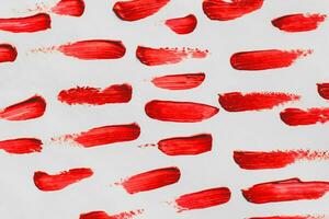 Smears of red cosmetic lipstick on a light background photo