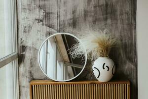 A modern vase with a mirror in a cozy interior photo