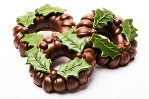 Detailed hand molded chocolate Christmas wreaths with edible holly isolated on a white background photo