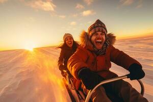 Cheerful couple tobogganing against stunning sunset on snowy slope photo