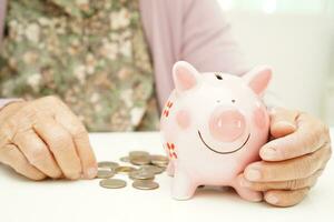 Retired elderly woman counting coins money and worry about monthly expenses and treatment fee payment. photo