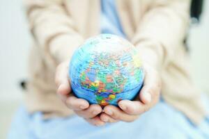 Bangkok, Thailand April 1, 2023 Asian elderly woman patient holding globe in hand at hospital. photo