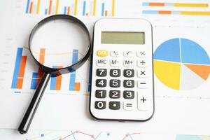 Magnifying glass on charts graphs paper. Financial development, Banking Account, Statistics, Investment Analytic research data economy. photo