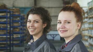 Beautiful female engineers smiling to the camera posing at the factory video