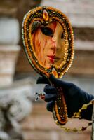 A mask in a mirror reflection a the Carnival of Venice photo