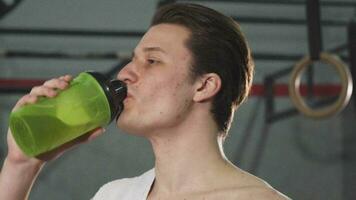 Young male athlete smiling joyfully drinking water video