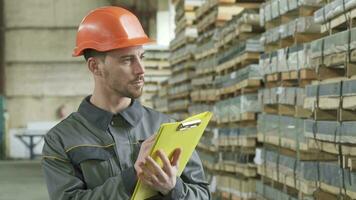 Warehouse worker writing on his clipboard standing at the storage video