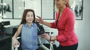 Happy little girl enjoying her hair being dried by a hairdresser at the salon video